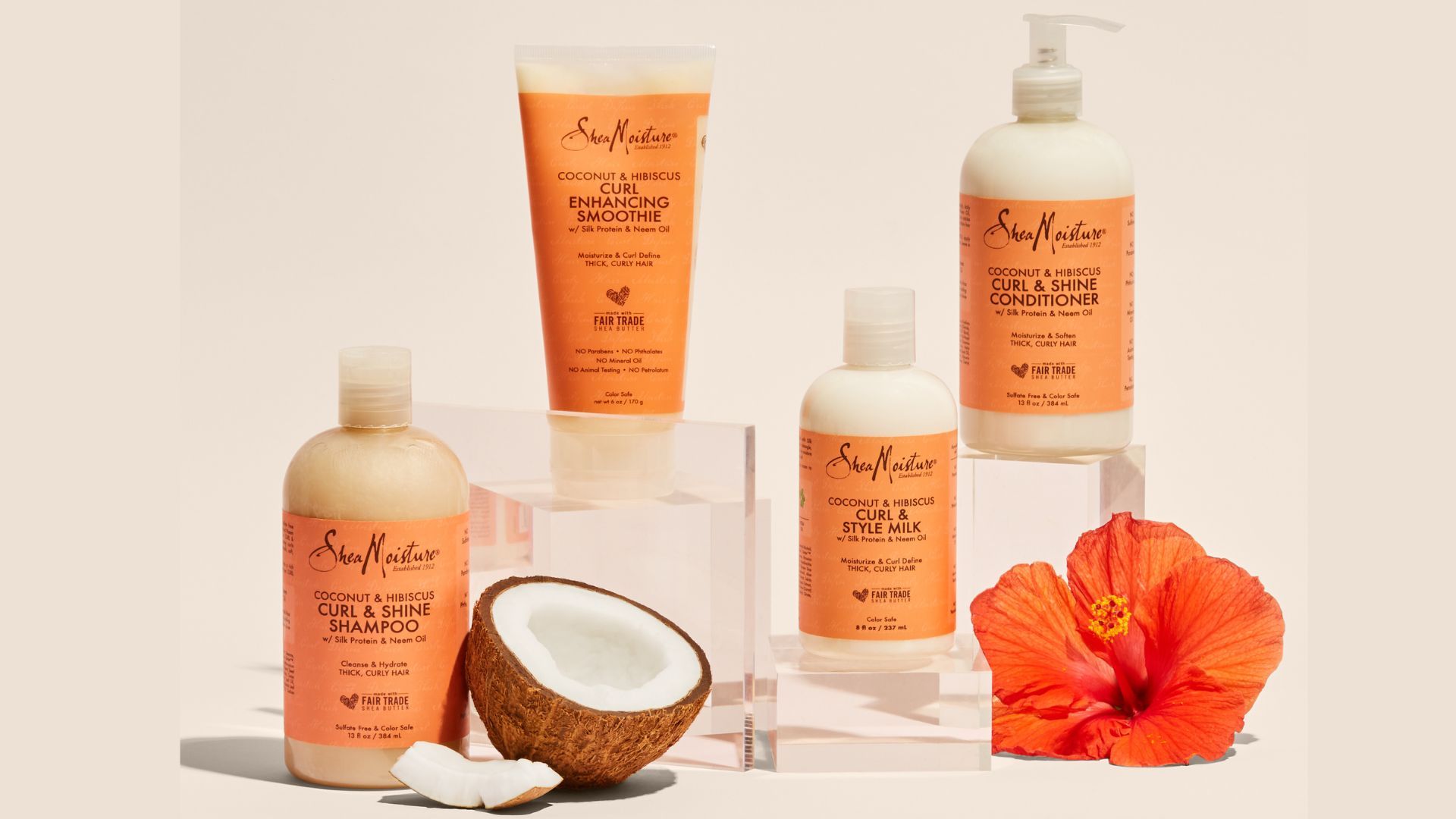 SheaMoisture Coconut & Hibiscus range of products lined up with a coconut and hibiscus flower