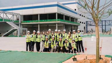 Reginaldo Ecclissato with a factory team in high vis jackets and hard hats