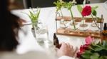 A scientist tests fragrance combinations in the lab. Pictured are roses, lily of the valley, vials and test tubes.
