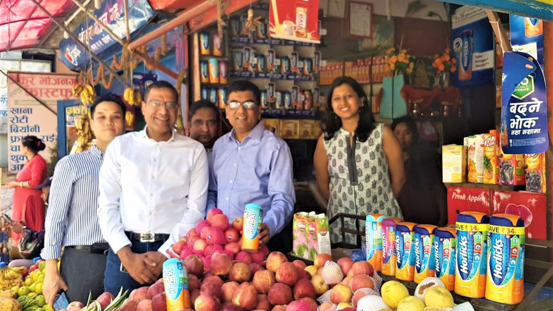 Group of people standing at a market stall for the launch of Horlicks in Nepal.