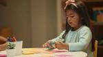 Smiling child writing to-do list.